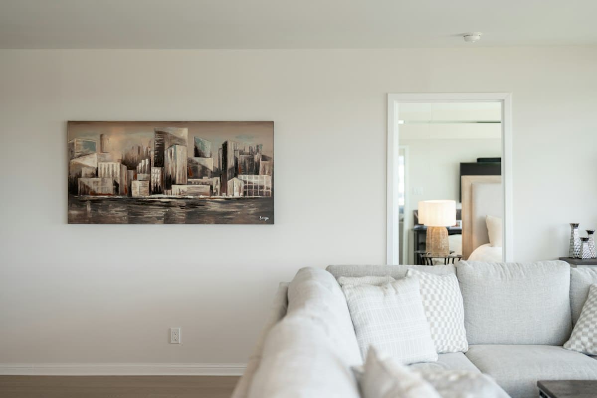 Pintura de paisagem urbana numa sala de estar luminosa e minimalista