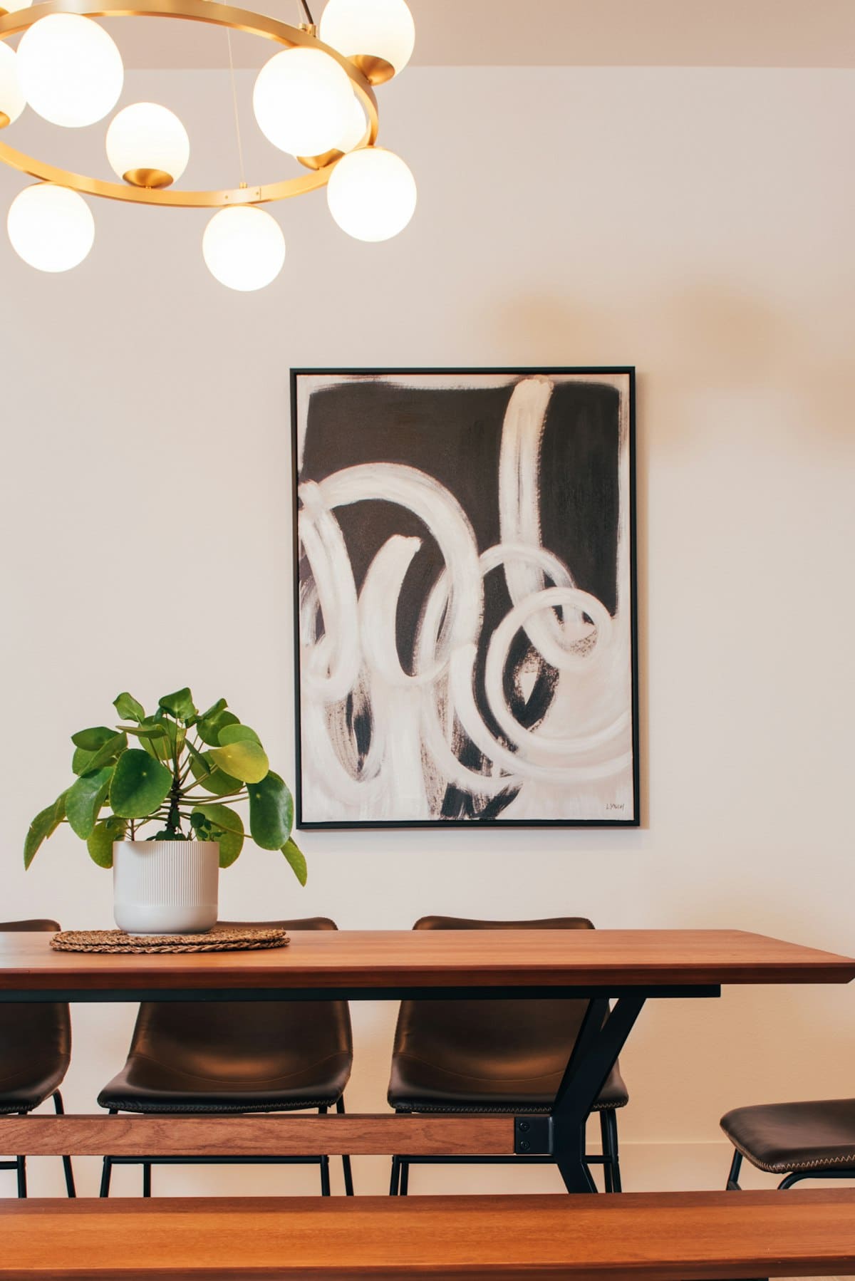 Pintura abstrata a pincel a preto e branco sobre uma mesa de jantar em madeira